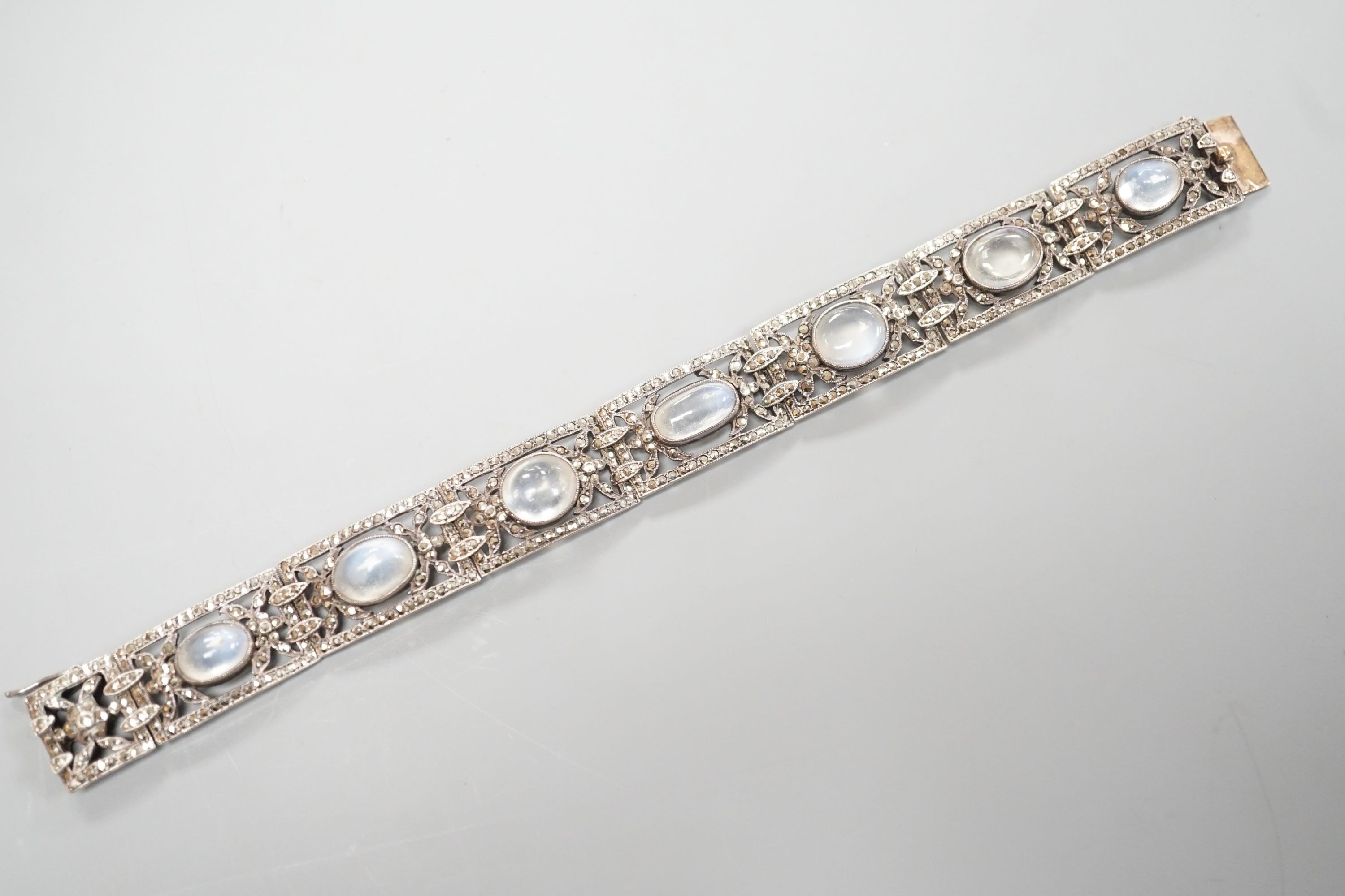 An early 20th century white metal, nine stone cabochon moonstone and marcasite set bracelet, 17.2cm.